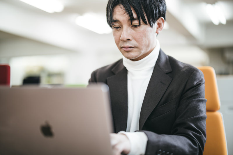 男性が真剣な表情でパソコンを見つめ作業